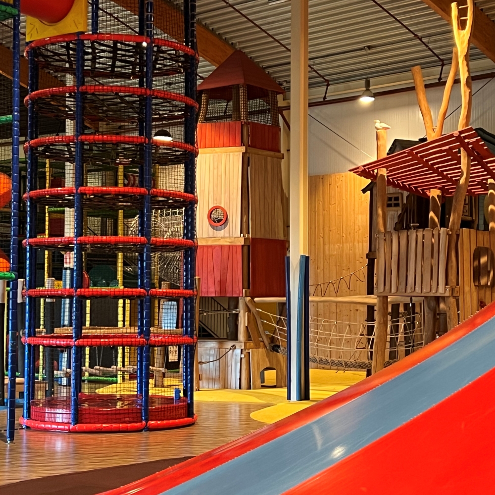 Grote binnenspeeltuin met klimstructuur en glijbanen in Middelburg